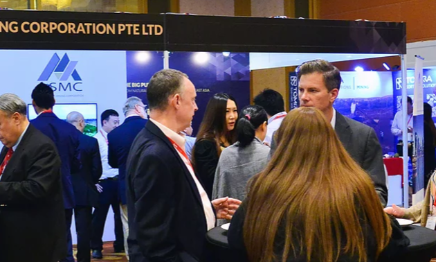 Men and women are gathered at a conference chatting with each other.