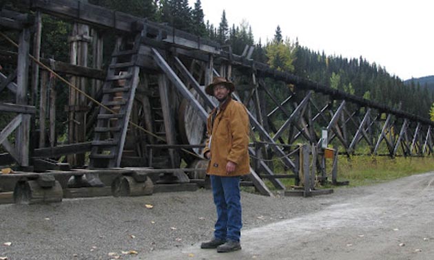 Mortensen standing in front of flume at Barkerville.