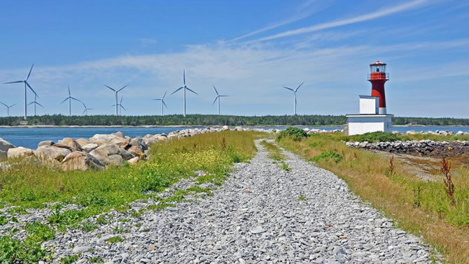 Picture of lighthouse with wind farm in the distance.