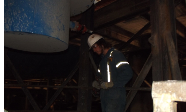 a man in coveralls and a hard hat