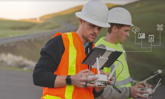 Two workers using tablets out in the field. 