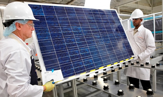Picture of worker assembling a solar power panel. 
