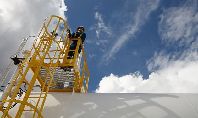 A oil worker standing on a platform.