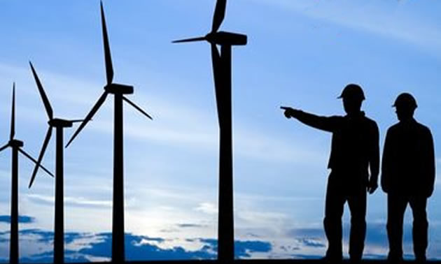 Silhouette of two people and wind turbines.