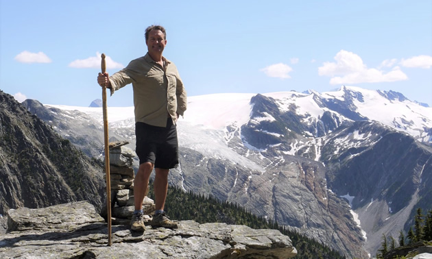 Bruce Madu is standing on top of a mountain.