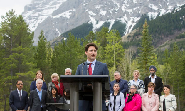 Justin Trudeau, standing at podium in Kananaskis, AB.