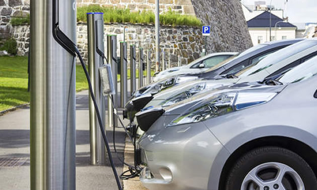 Cars lined up at EV charging stations. 