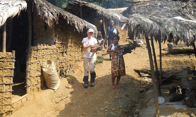 Helping local woman in camp collecting firewood for dinner after a long day in the field. This is a jungle artisanal mining camp SE Liberia 2010.