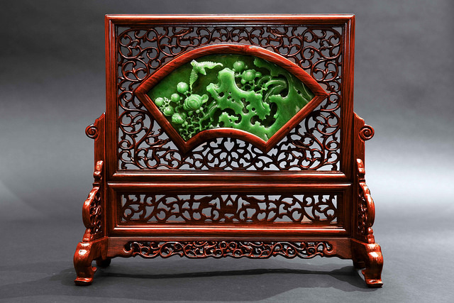 Skillfully framed in precious wood, the jade screen stands tall as a proud work of art.