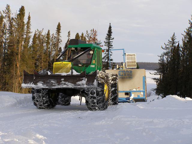 Workers move a drill over to the Cree East camp in the Athabasca Basin.