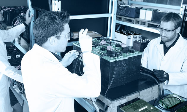 Picture showing technicians working on electronics in a lab. 