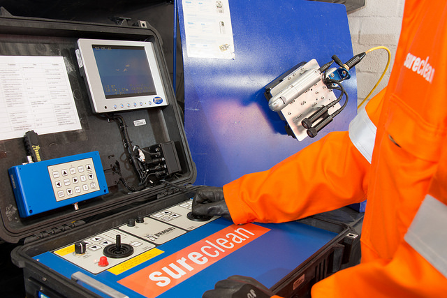 Sureclean uses Inuktun Pelican Case Controller with MicroMag on Steel Wall in Background.