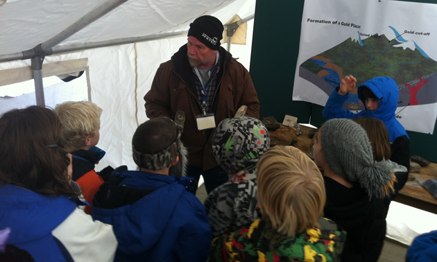 A miner teaching school aged children about exploration.