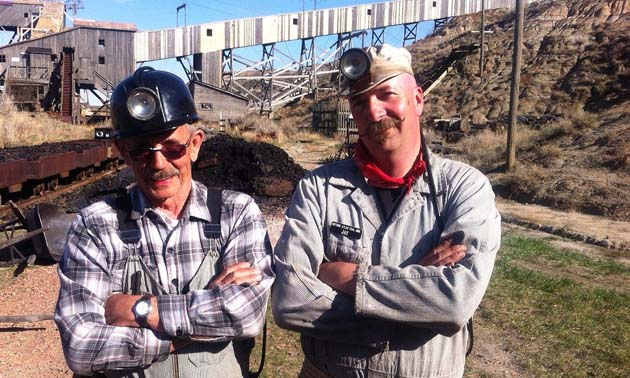 Bob Moffatt and Jay Russel, Executive Director at Atlas Coal Mine, pose in mining clothes on the site.