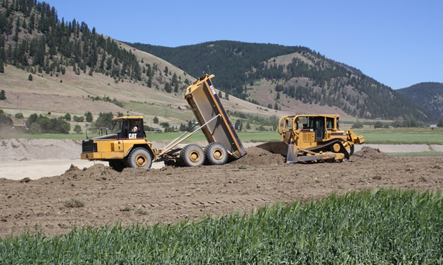 a dumptruck and dozer working