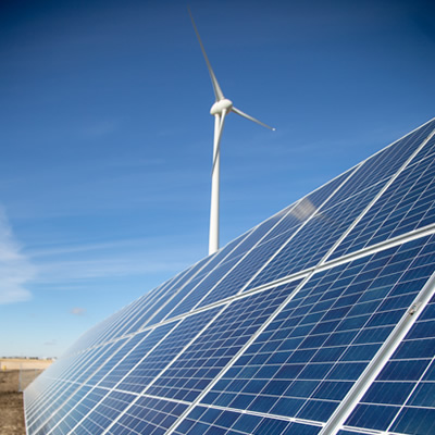 Solar panels in front of a wind turbine are shown. Phase 2 of the Cowessess Renewable Energy Storage Facility consists of 1,134 photovoltaic panels. 
